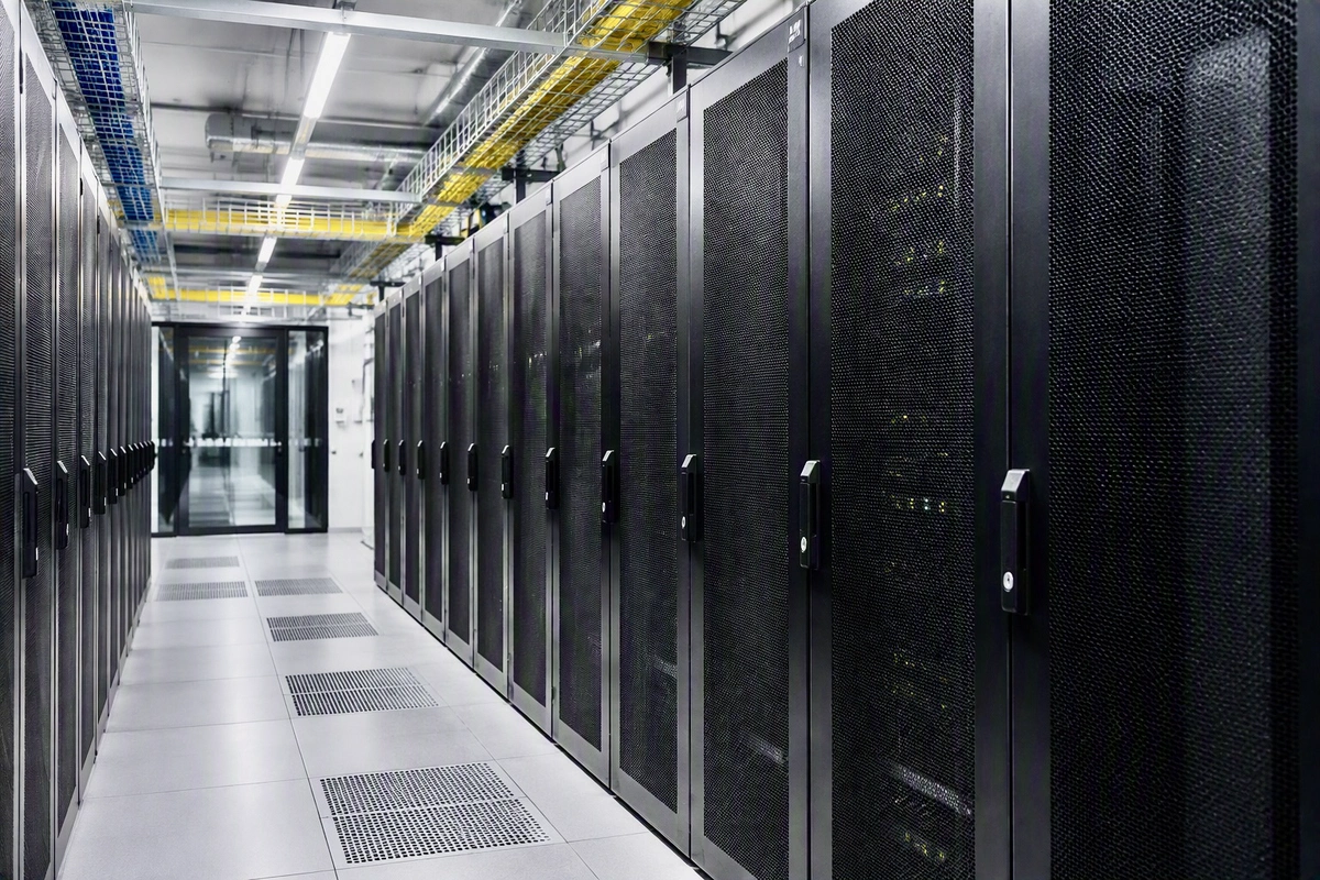 Server room with raised floor and overhead cable tray, rows of server cabinets